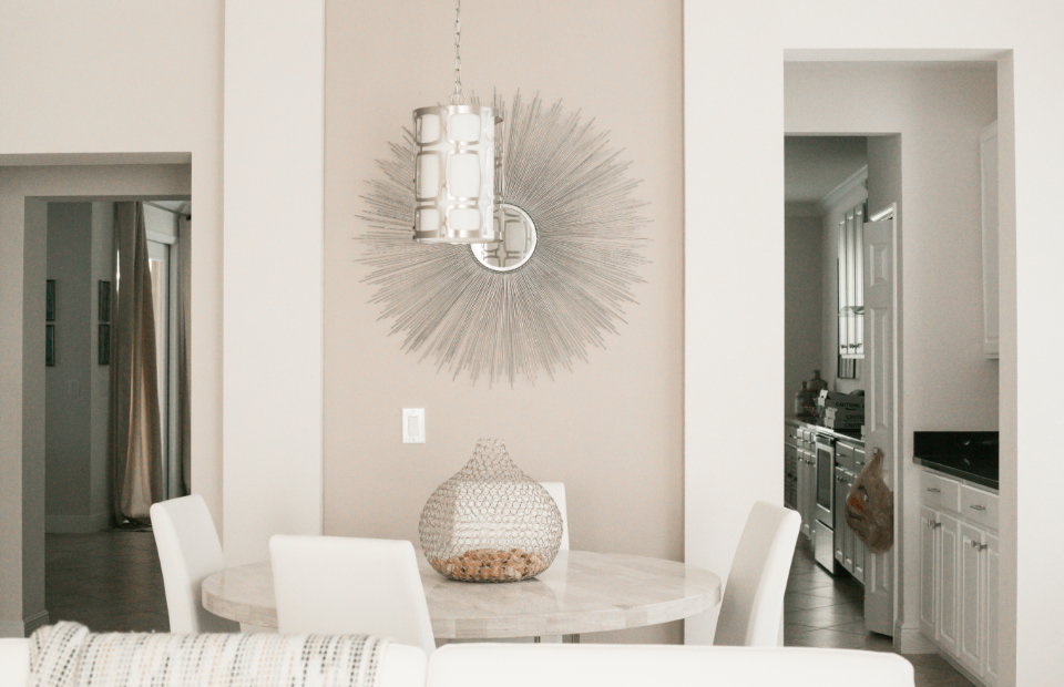 Bright white entryway with a round mirror and pendant light